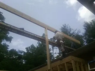 Carpenter setting a ridge beam over a new addition frame — Ice Dam Removal by Roofing Brothers in Macclesfield
