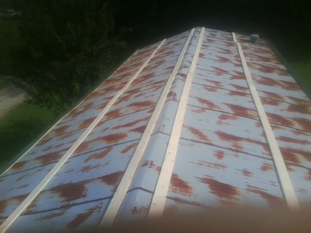 Rusted metal roof panels with new wood purlins before replacement — Storm Damage Roof Repair in Macclesfield by Roofing Brothers